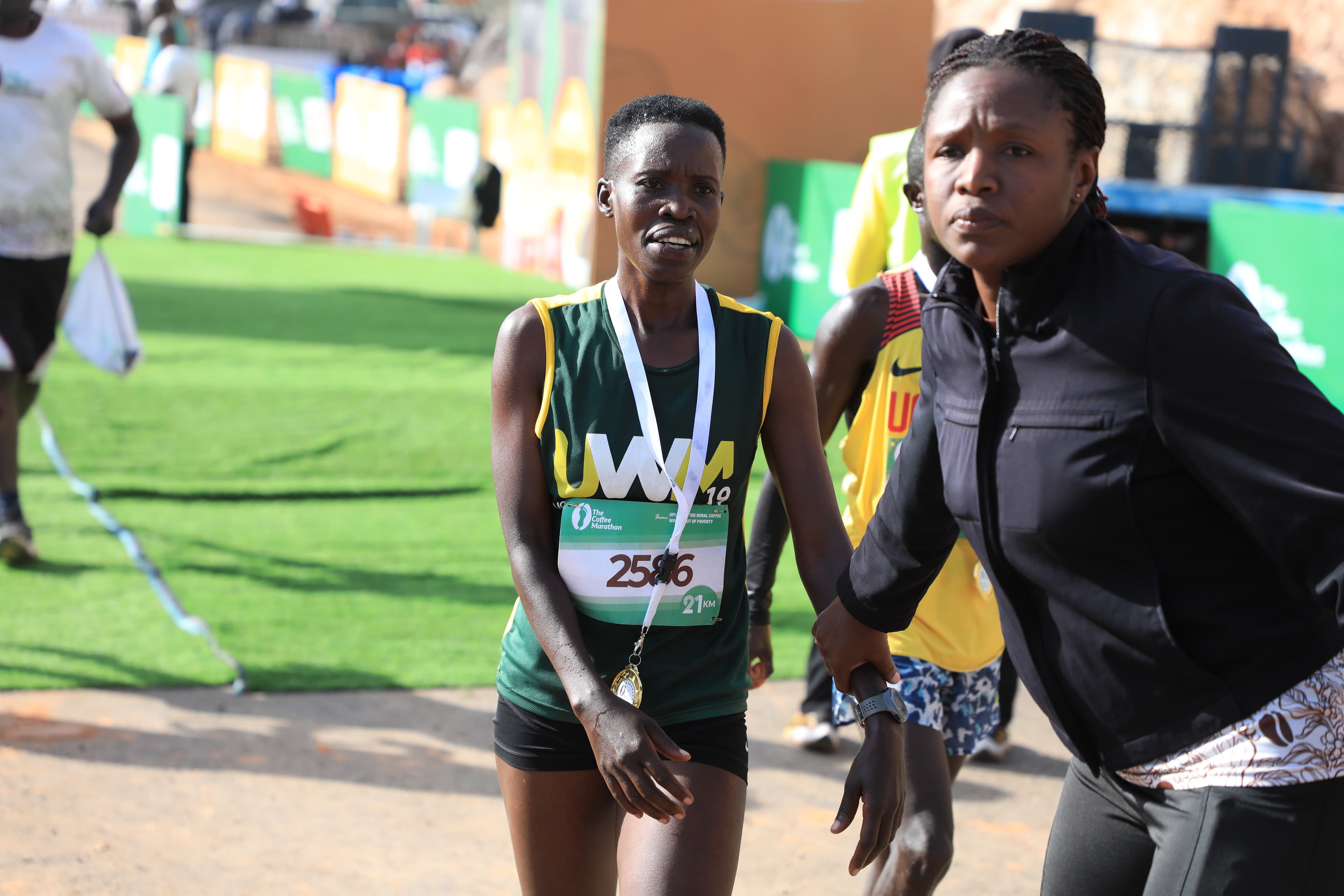 Female runner crossing the finish line — Coffee Marathon 2025